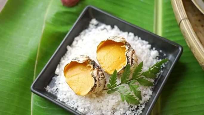 泰国北方风味的烤味噌蟹放在香蕉叶上的黑盘中。