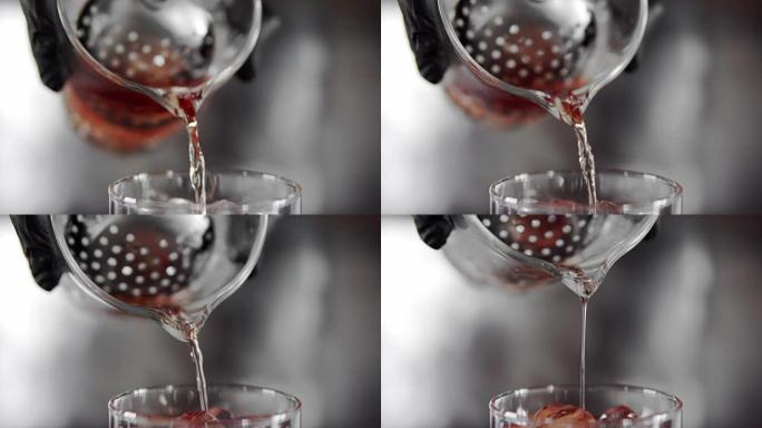 大量的红色马提尼酒倒入装满冰块的玻璃杯中。马提尼酒在杯子里加冰。制作鸡尾酒。内格罗尼。