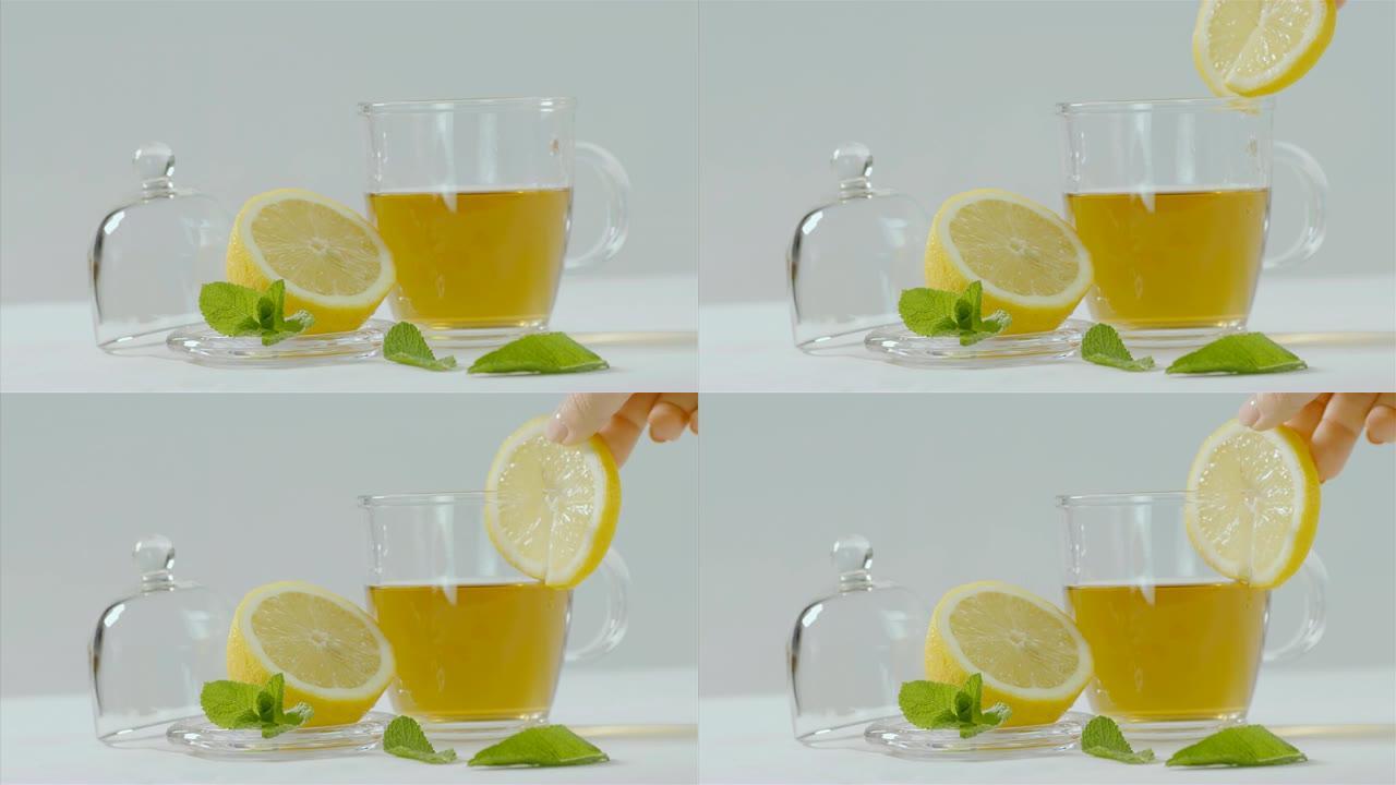 凉茶倒入透明茶壶，柠檬和薄荷叶周围，75 fps慢动作