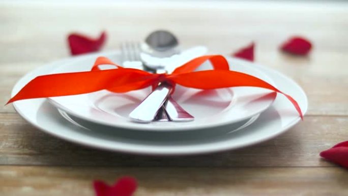 餐具的特写，盘子上系着红丝带