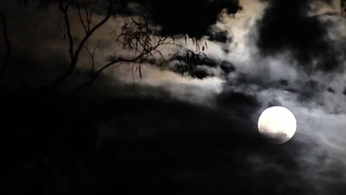 满月在多云的夜空上投射光