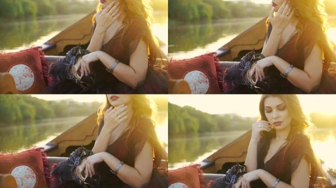 一位穿着有效礼服的神秘女人在日落时若有所思地看着贡多拉河。