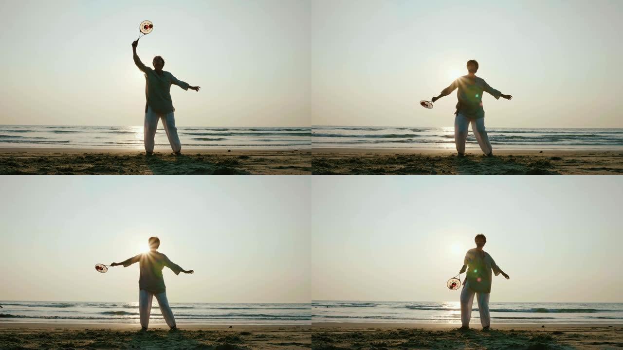 日落时在海滩上练习太极拳气球的高级女子