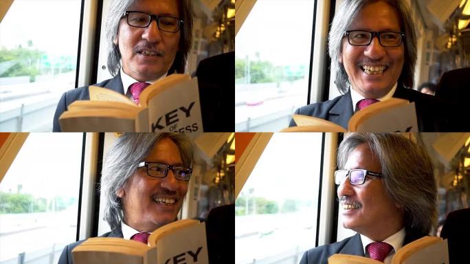 戴眼镜的高级商人带着微笑在火车上读一本关于商业成功的书