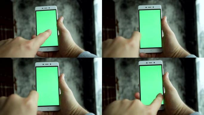 特写镜头手握和触摸绿屏垂直手机