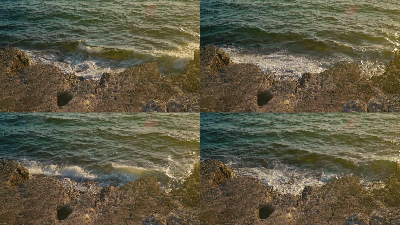 海浪席卷岩石海岸，产生海沫。