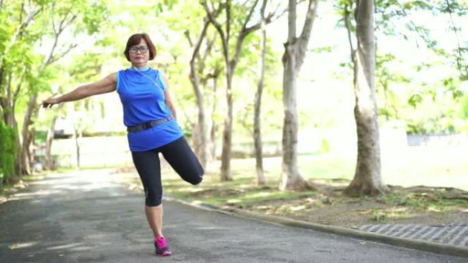 亚洲高级女性在公园伸展大腿肌肉