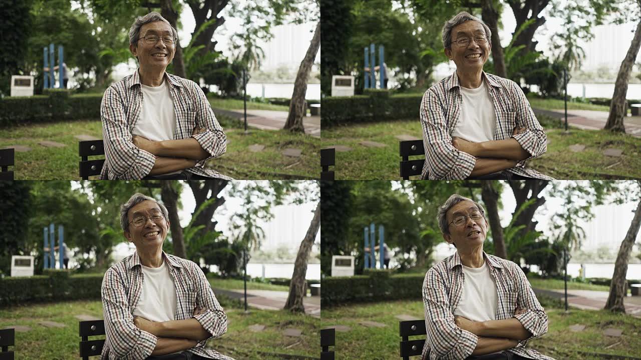亚洲资深男子独自坐在公园微笑