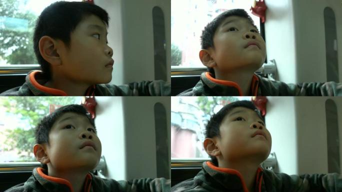 亚洲男孩在公车上看电视