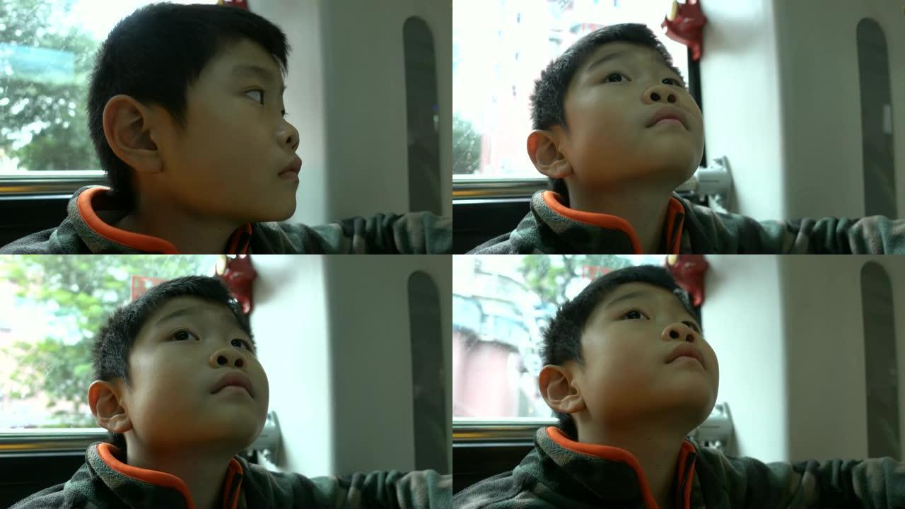 亚洲男孩在公车上看电视