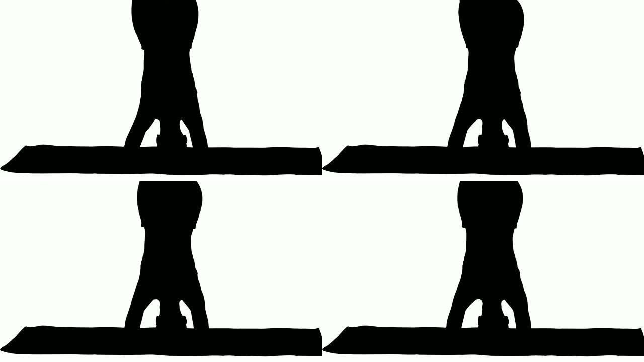 剪影美丽的年轻女子做瑜伽运动的变化支撑倒立，鹰航salamba sirsasana交叉腿
