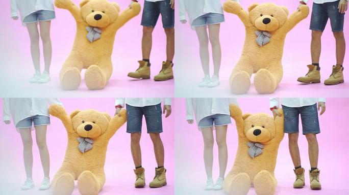 浪漫的年轻夫妇站在一起抱着娃娃熊。