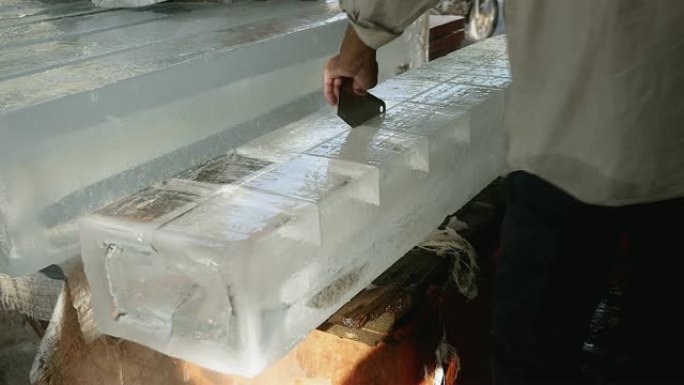 冰卖家用圆锯从较大的冰块中预切小块冰块 (特写)