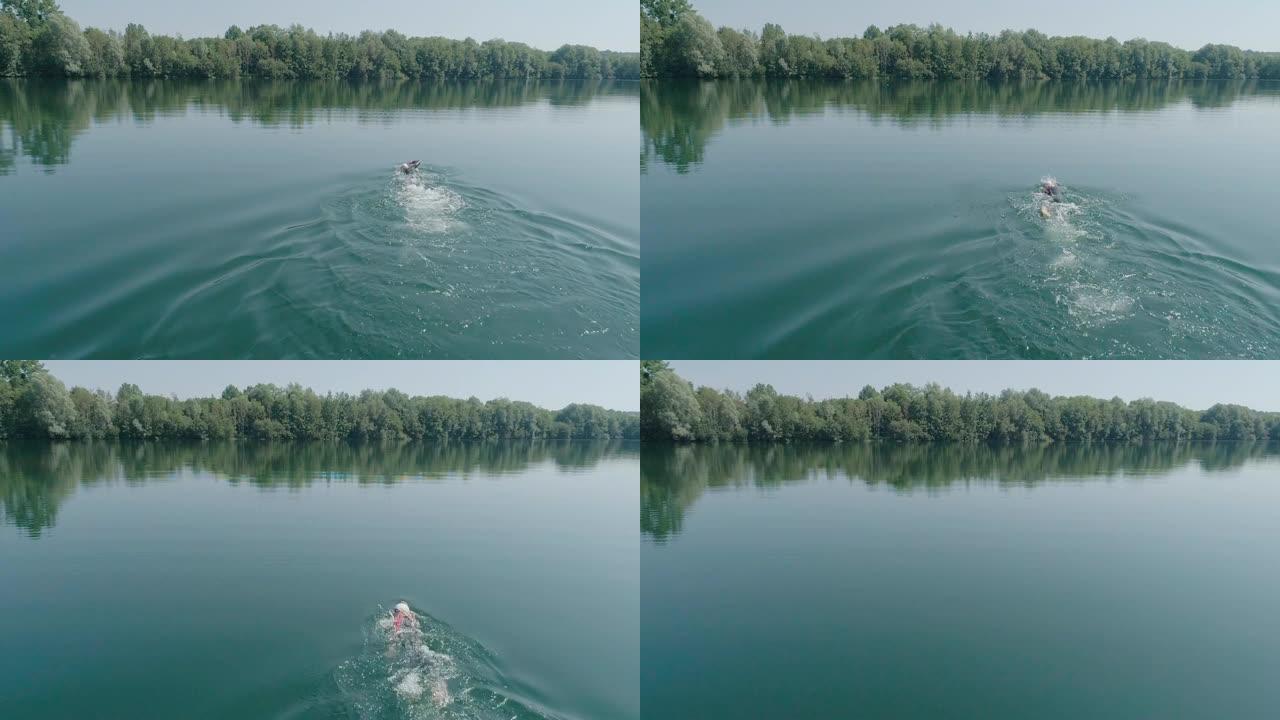 铁人铁人三项运动员男子训练的空中射击。男子在铁人三项比赛的湖泊训练中游泳的无人机射击