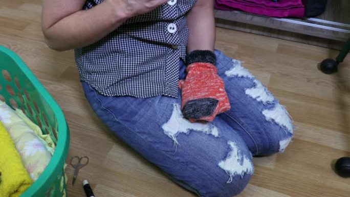 女人坐在地板上修理袜子