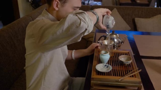 男子在仪式上在茶盘上准备传统的日本茶