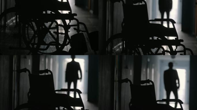 沿着医院走廊向轮椅行的男子剪影