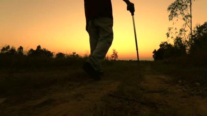 老人使用员工在日落时行走，概念健康，慢动作