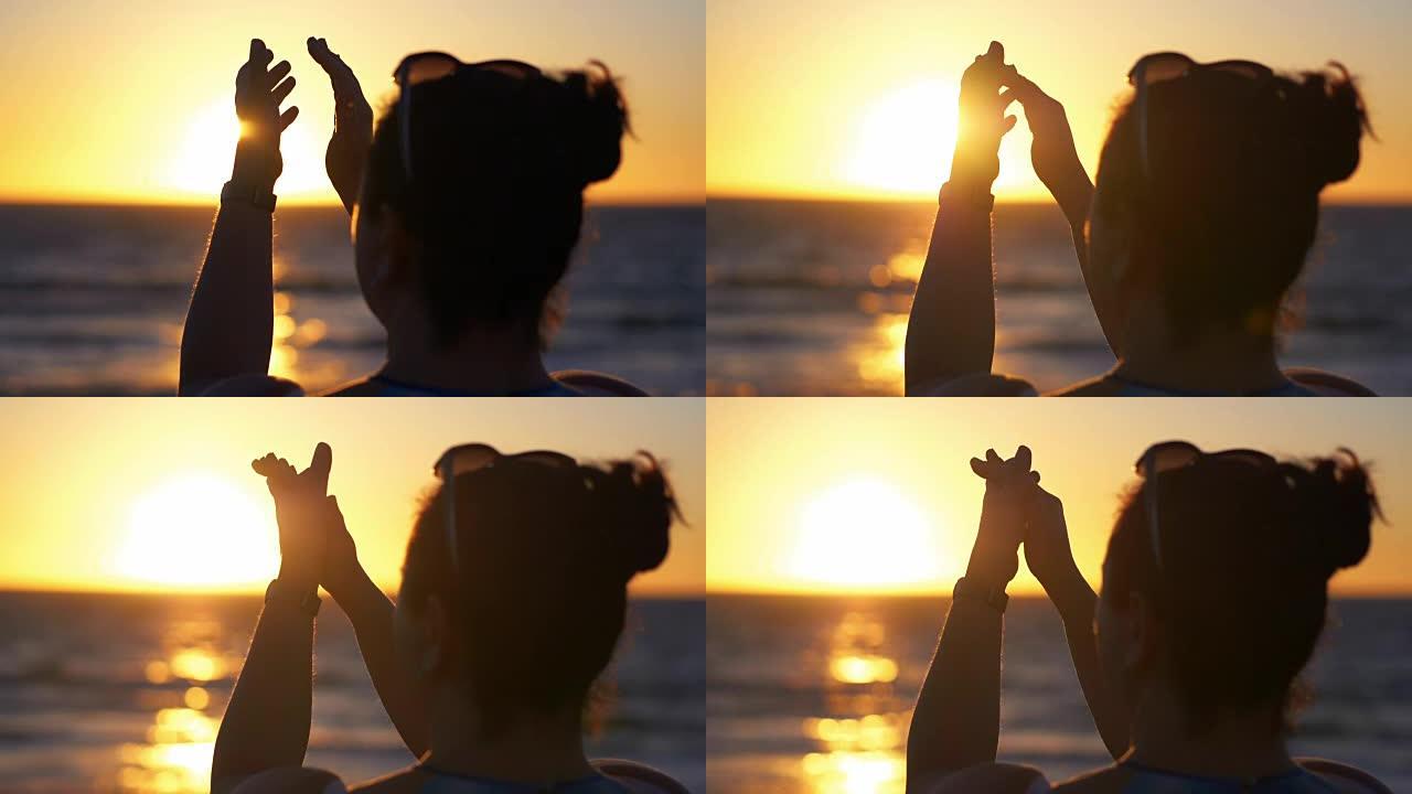 女人在日落时以慢动作180fps拍手