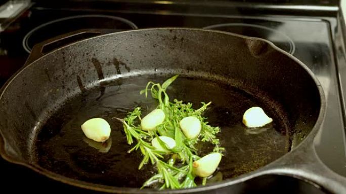 在橄榄油中烘烤的大蒜，迷迭香和龙蒿
