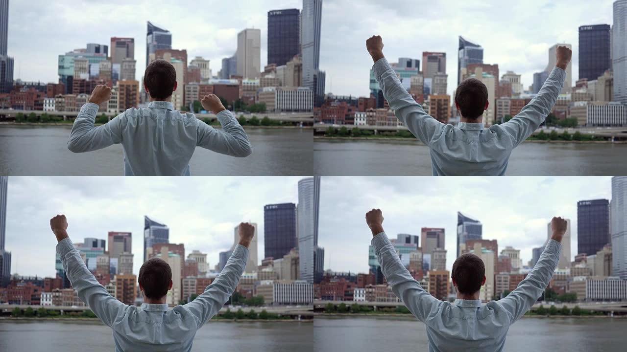 一名男子在庆祝电影天际线的胜利姿态中举起手臂