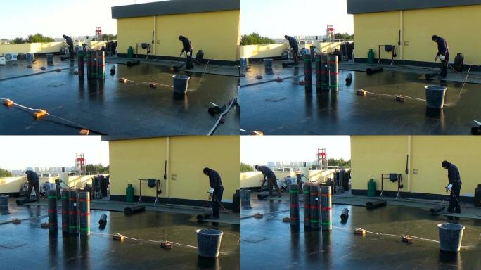 工人准备沥青屋顶毛毡辊的一部分，用于通过燃气加热器火炬火焰熔化