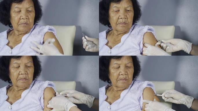 医生将疫苗注射到老年妇女的肩膀上