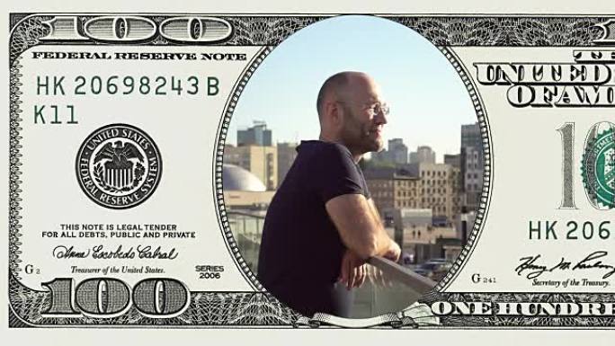 男子站在阳台上的框架100美元钞票