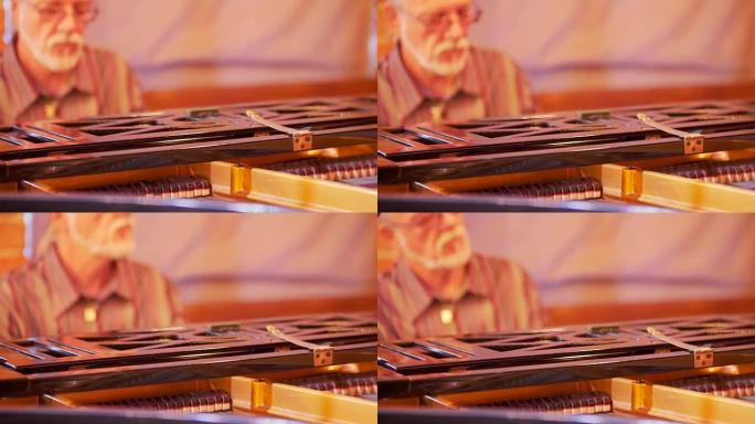在前台是在演奏音乐家时操作钢琴键的过程。在背景中，一个白发男子弹钢琴