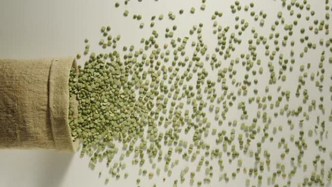 慢动作: 绿豌豆从掉落的麻袋中倒出-俯视图