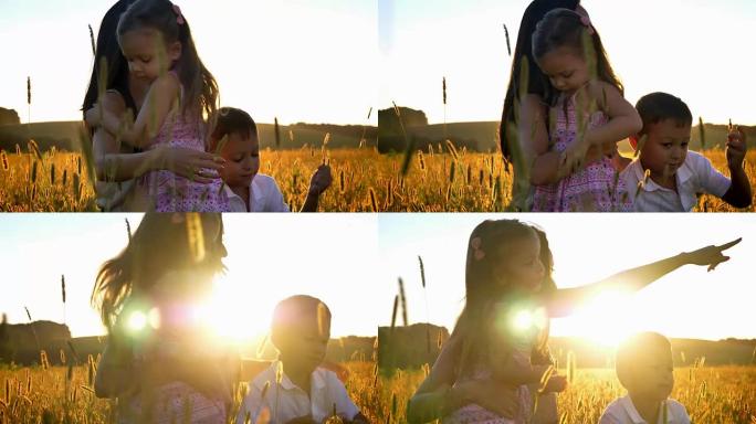 带孩子的亚洲母亲夏天在田间散步，坐在小麦中，拥抱女儿，家庭观念