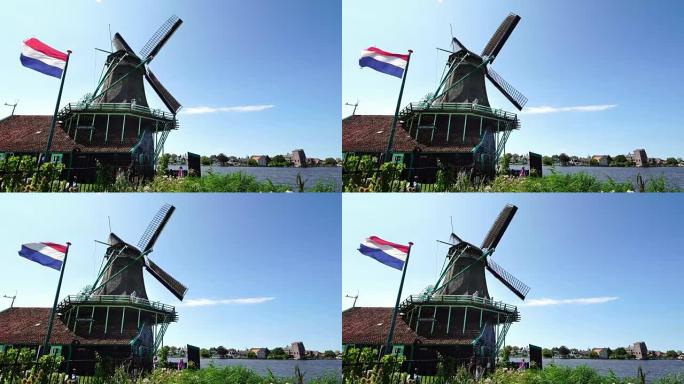 为荷兰阿姆斯特丹附近的传统风车Zaanse Schans拍照的游客