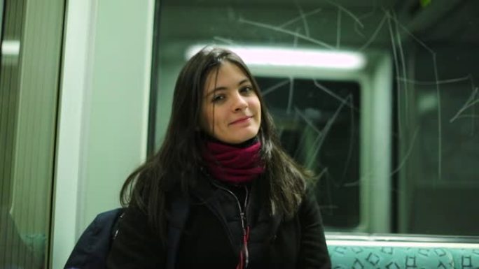 乘坐地铁时，女人直接看着相机微笑