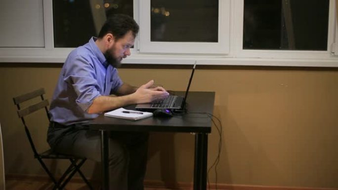 一个疲惫的商人在深夜工作，办公室里有一台笔记本电脑，并撰写财务报告。
