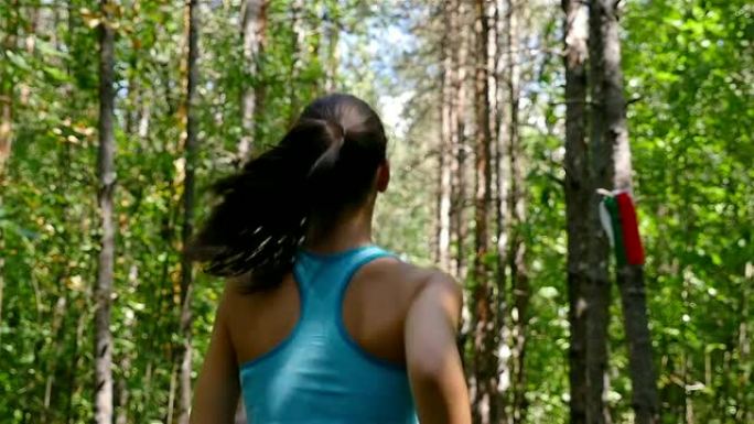 跟踪女孩在公园、木头、森林、慢动作中慢跑的摄像机