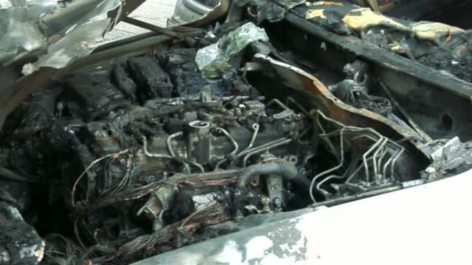 火灾后的汽车。开着引擎盖的烧毁的汽车。