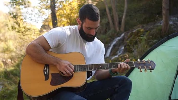 一个男人喜欢在露营时弹吉他