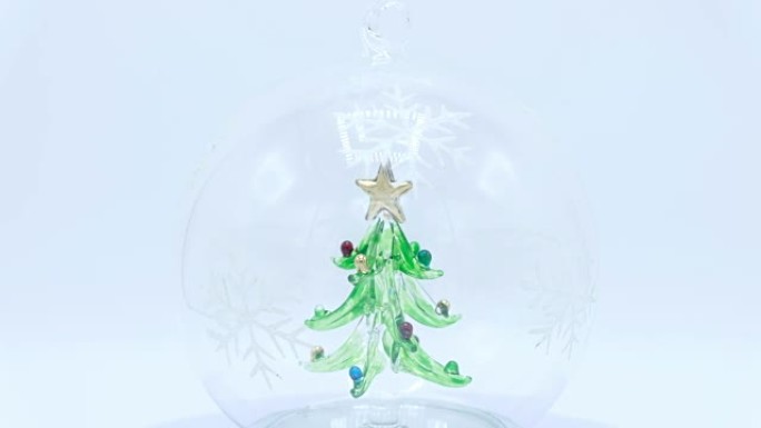 白色背景玻璃球内的圣诞树。
