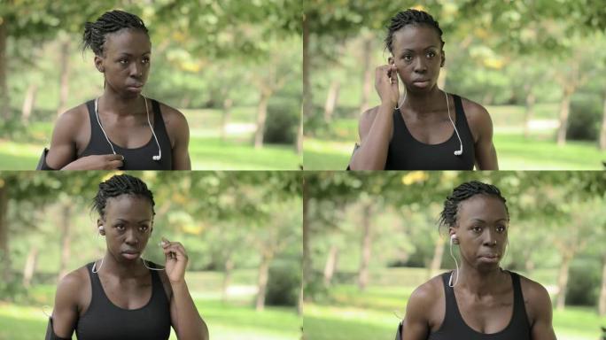 专注，运动。运动员戴着耳机的非洲女人