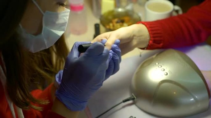 女人用凝胶上光剂覆盖指甲给客户