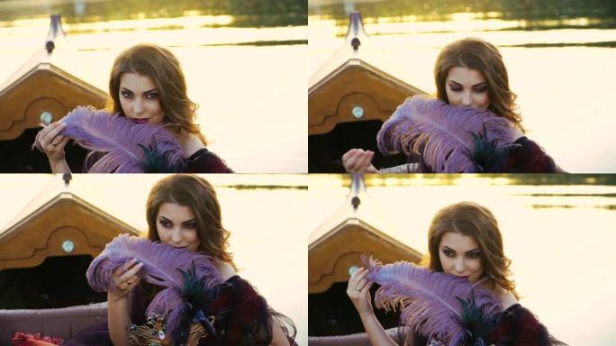 一位美丽的女人坐在缆车上，在日落的模糊背景上触摸带有狂欢节面具的紫色羽毛