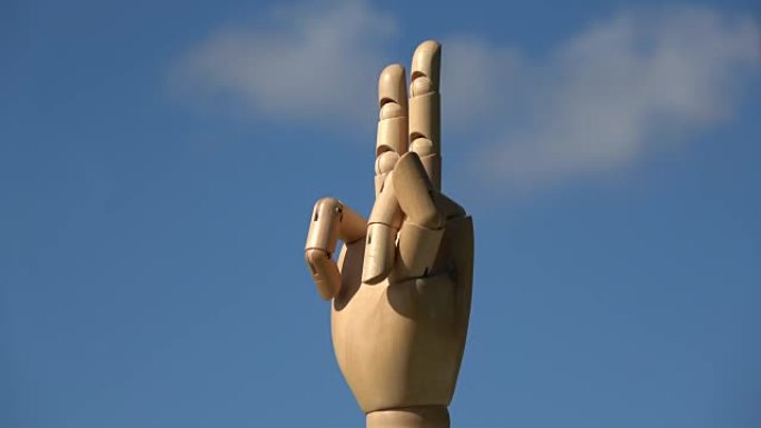 旋转木制人体模型手显示两个手指胜利手势符号