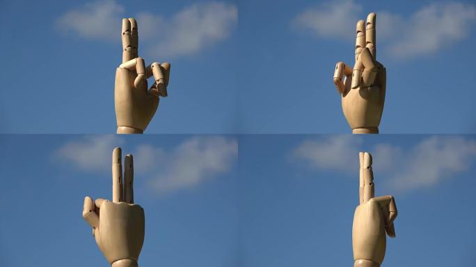 旋转木制人体模型手显示两个手指胜利手势符号