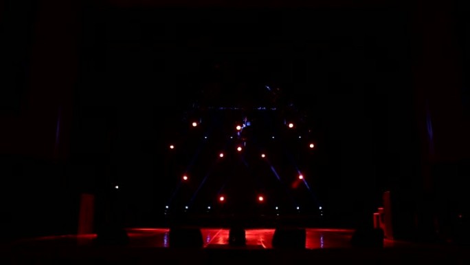 在黑暗中空荡荡的音乐会舞台上，红色的聚光灯呈心形。
