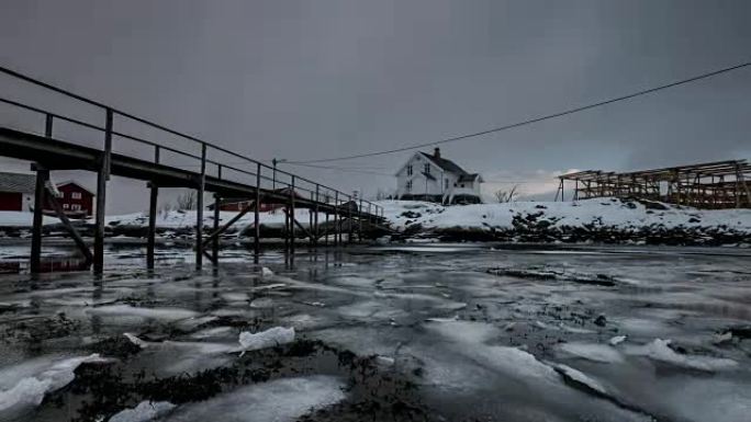 挪威罗弗滕群岛的暴风雪中的木屋在海岸线上漂浮的冰破裂的时间流逝