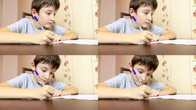 一个男孩坐在家里的桌子旁，用笔在纸上写字