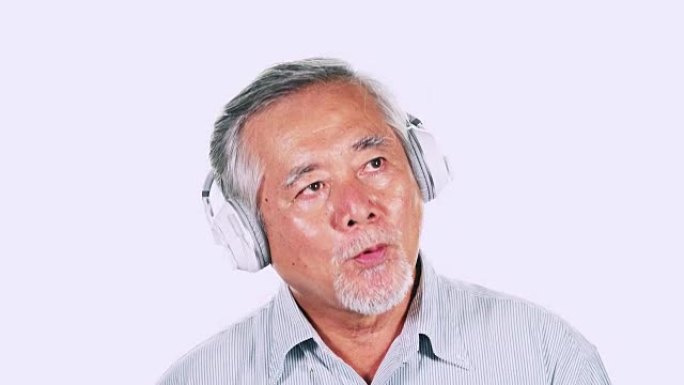 老人使用隔离在白色背景中的耳机听音乐。白胡子的亚洲男人。高级生活方式概念。
