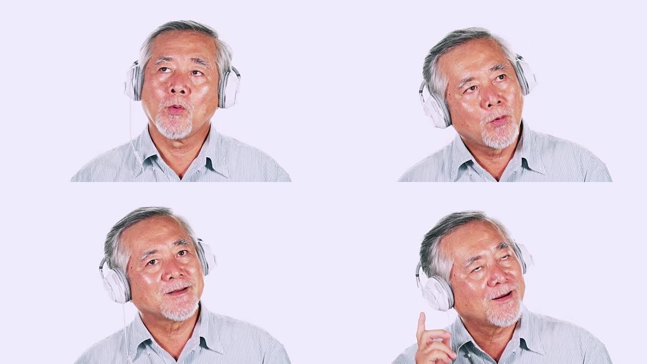 老人使用隔离在白色背景中的耳机听音乐。白胡子的亚洲男人。高级生活方式概念。