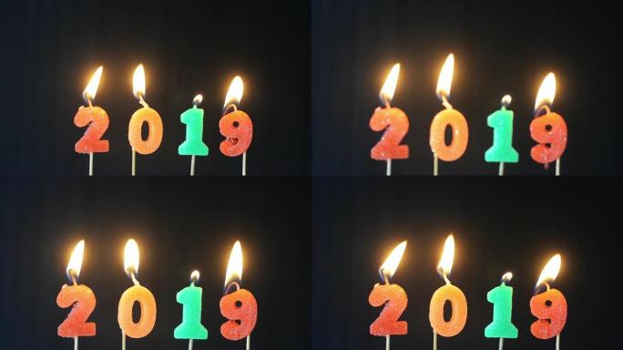 点燃蜡烛新年快乐2019与sparkler彩色闪光蜡烛数字燃烧闪耀黑色背景倒计时从年底和庆祝日欢迎来