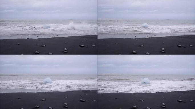 在Jokulsarlon Diamond's beach的冰岛黑沙滩上，海浪在冰山上飞溅的慢动作视频